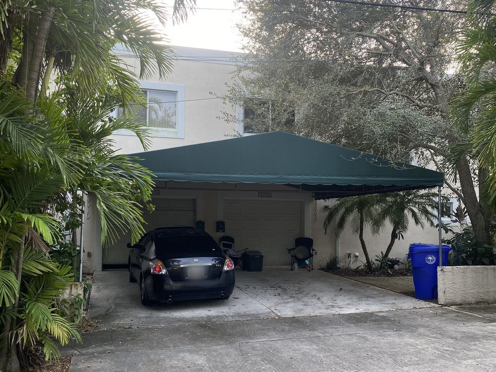 A Coconut Grove house before renovation, under a green canvas carport