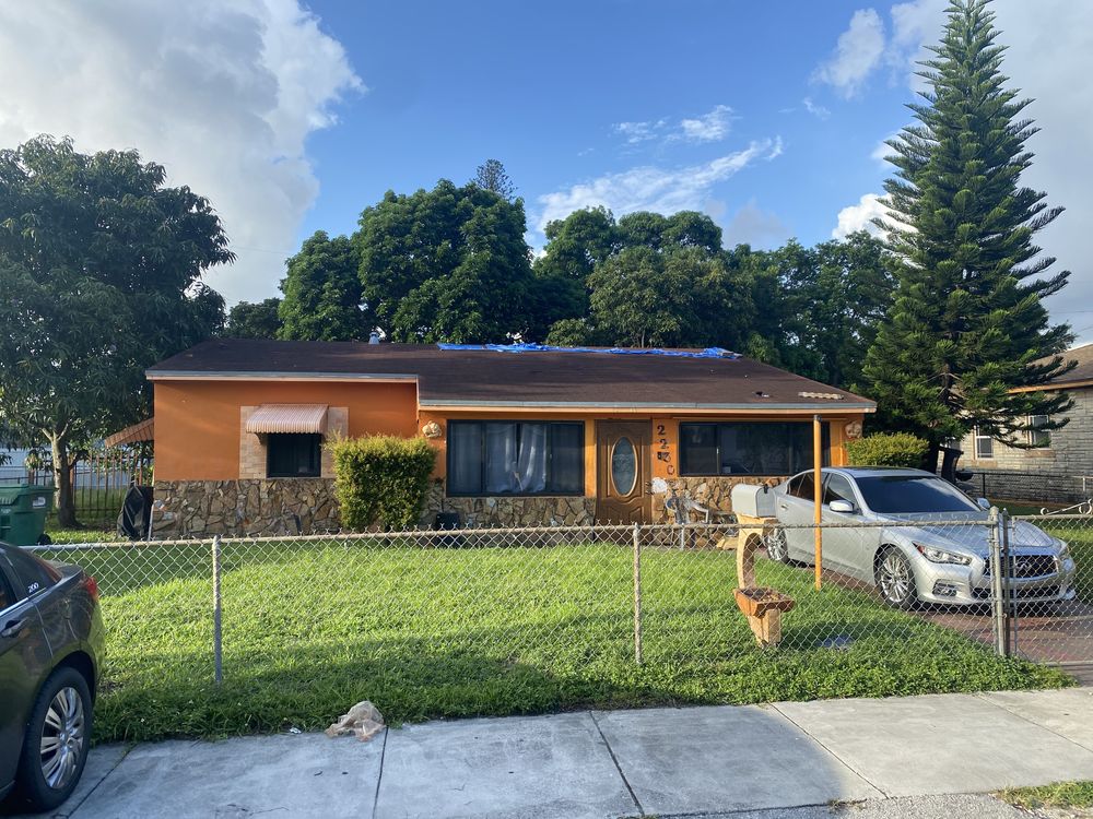 A West Little River house before renovation, painted orange, with a failing roof